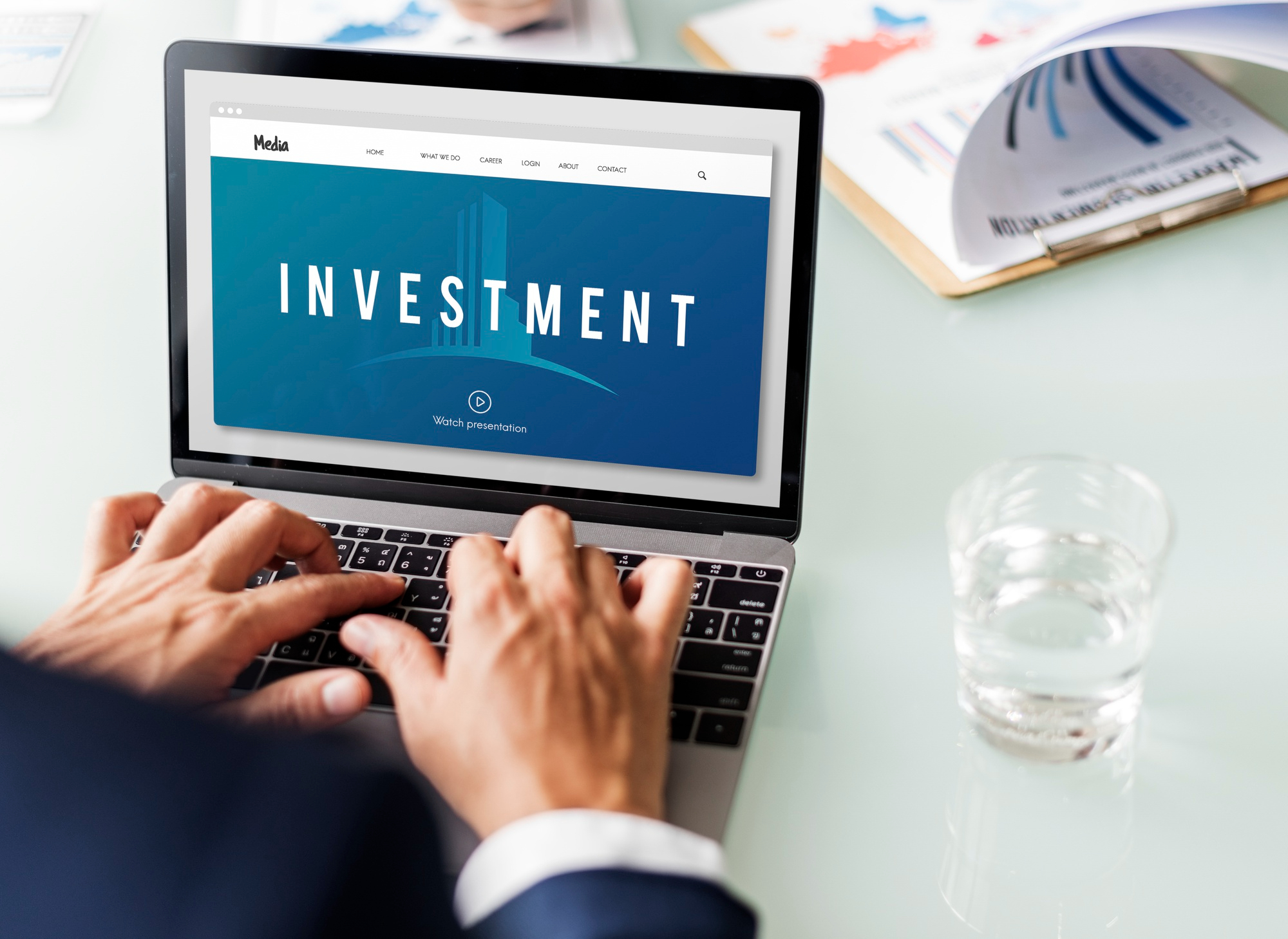Businessperson researching investment opportunities with 'Invest' highlighted on the screen.